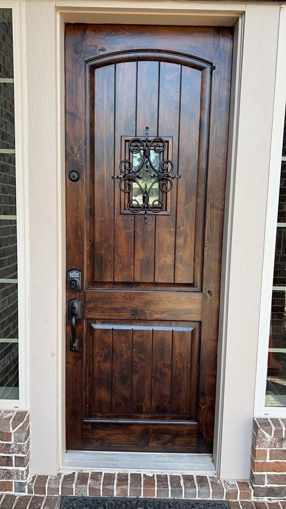 A rustic arched plank door with an iron speakeasy grille, fully restored