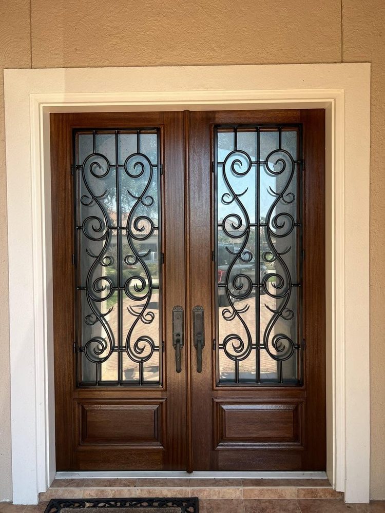 Mahogany double doors with wrought-iron scrollwork, restored