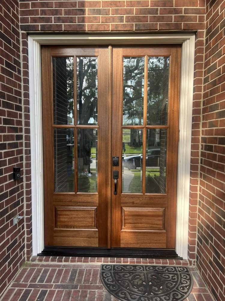 Mahogany double doors replacing a damaged black entry door