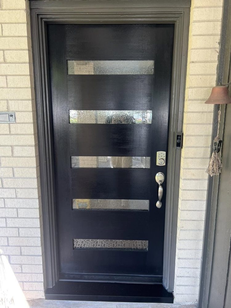 A black modern entry door with five horizontal glass lites