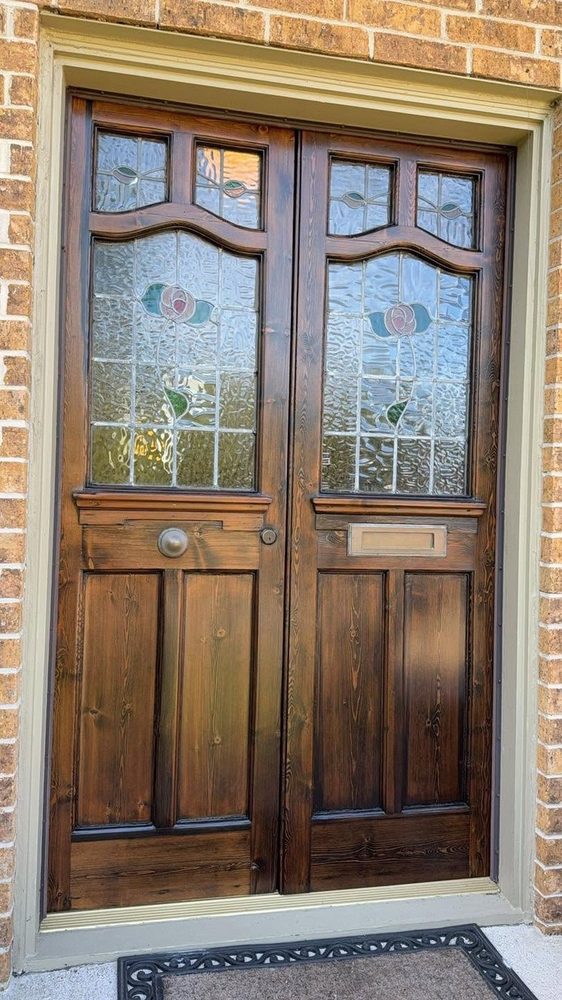 Double doors with arched leaded glass in a warm refinished stain